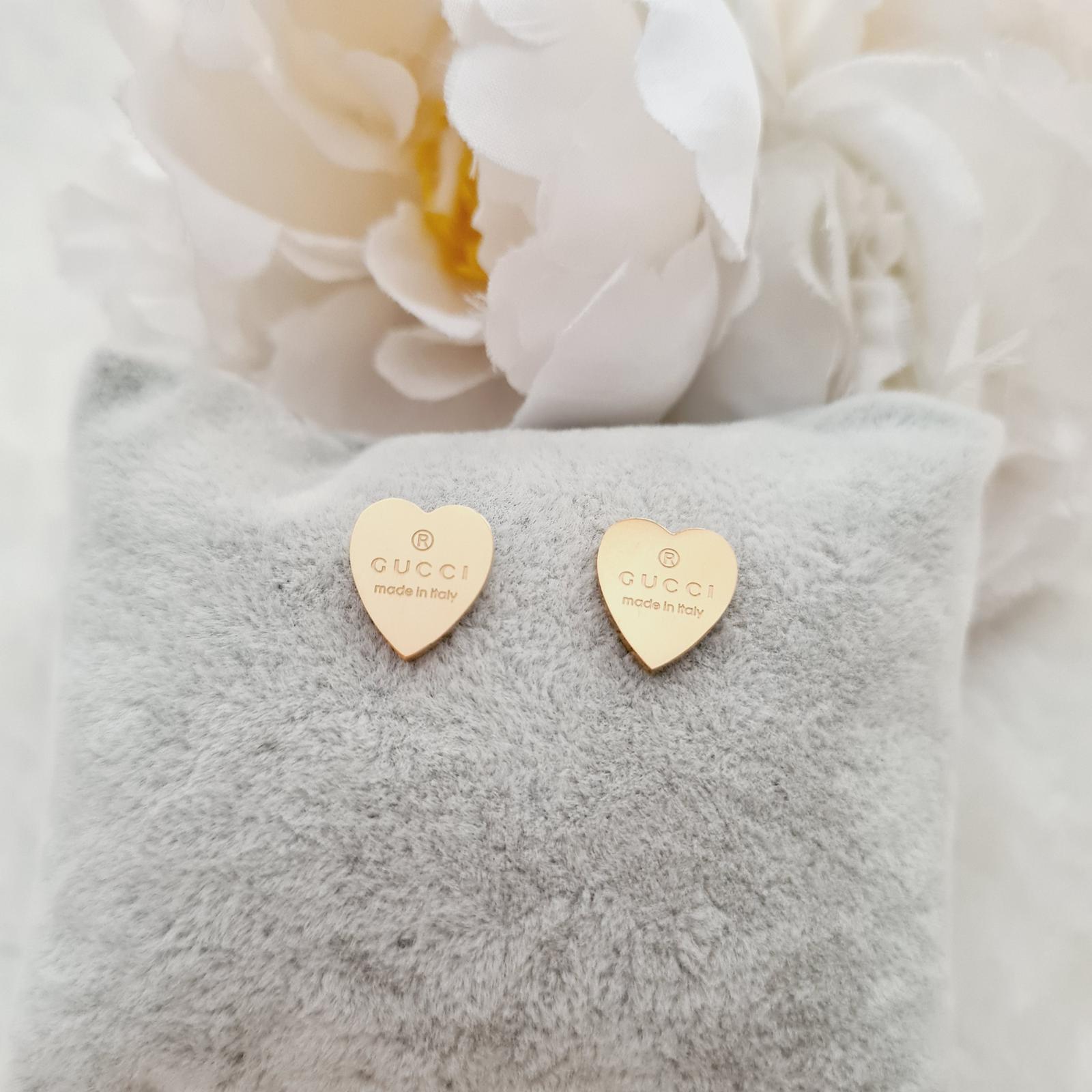 Gold heart earrings with a classic designer touch.